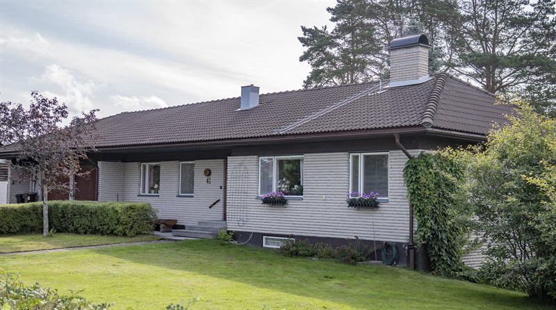 Hvit enebolig med rent tak etter behandling